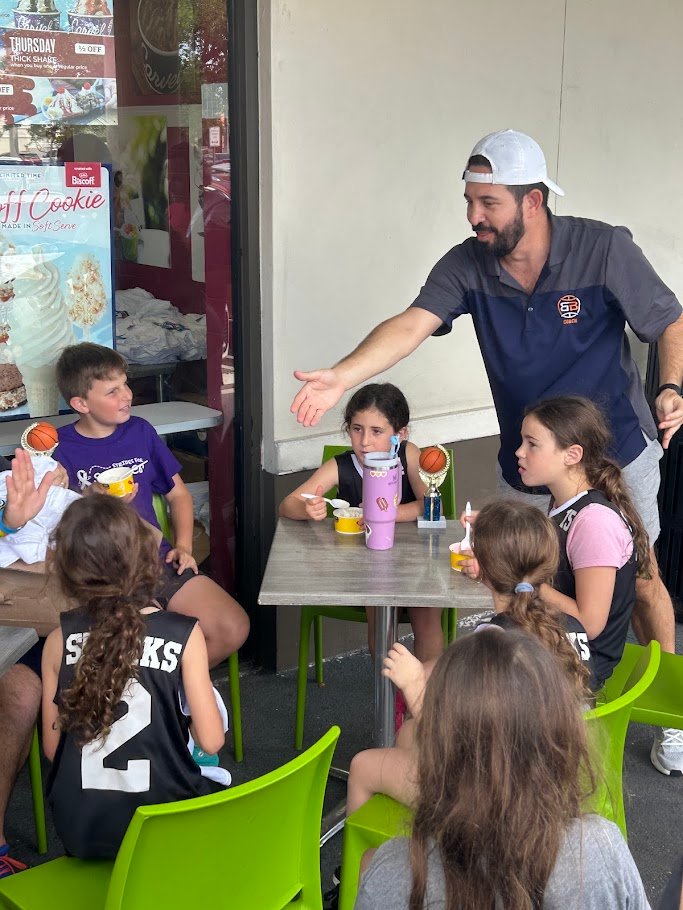 Boca Basketball coach celebrating with young players after a game in West Boca Raton