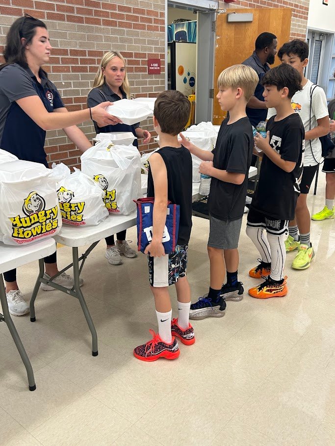 Boca Basketball summer camp staff handing out Hungry Howie's lunch to campers